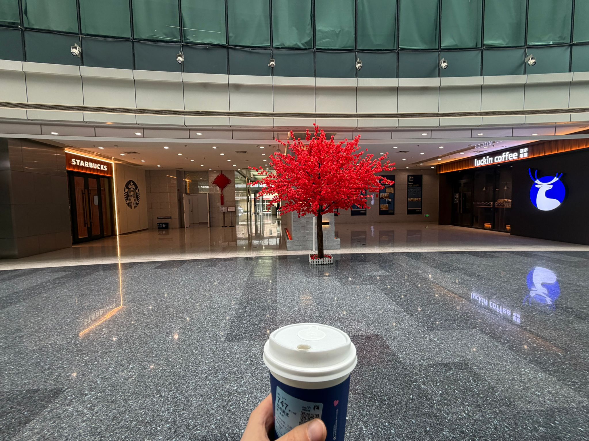 A Luckin Coffee and Starbucks facing each other inside a Chinese mall
